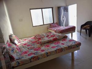 a bedroom with a bed and a couch and a window at DWARKA BUNGALOW Only Family Full Bungalow in Dwarka