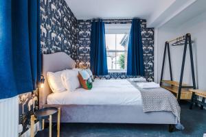 a bedroom with a bed with blue curtains and a window at ZooBlu: Chester 1-Bed in Chester