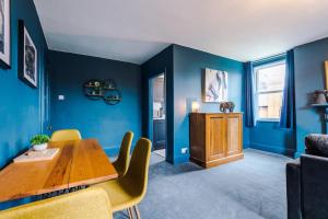 a dining room with blue walls and a wooden table at ZooBlu: Chester 1-Bed in Chester