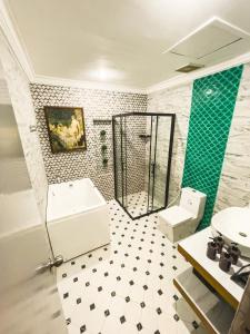 a bathroom with a sink and a tub and a toilet at Miramar Hotel in Manila