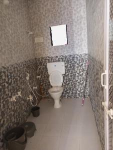 a bathroom with a toilet and a window in it at DWARKA BUNGALOW Only Family Full Bungalow in Dwarka