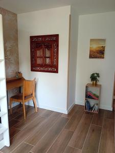 a room with a chair and a desk and a picture on the wall at Appartement Maeva in Saint-Pée-sur-Nivelle