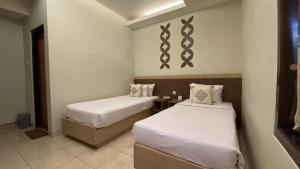 Llit o llits en una habitació de Mawar Asri Hotel