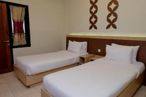 Llit o llits en una habitació de Mawar Asri Hotel