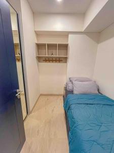 um pequeno quarto com uma cama e um armário em Brand new 2BR Empire Tower - Podomoro City em Medan