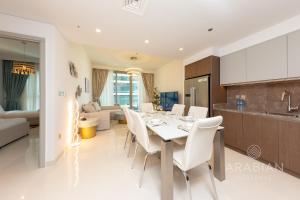 a dining room and living room with a table and chairs at Brand New 2BR Apt with Palm Views and Private Beach - High Floor in Dubai