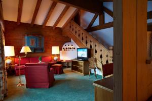 a living room with a couch and a television at Sporthotel Lorünser in Zürs am Arlberg