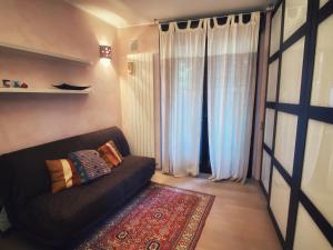 sala de estar con sofá negro y alfombra en Sauna & Jacuzzi 15 minutes from Malpensa MXP, en Olgiate Olona