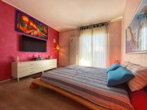 een slaapkamer met een bed en een tv aan de muur bij Sauna & Jacuzzi 15 minutes from Malpensa MXP in Olgiate Olona