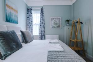 a bedroom with a large white bed with blue walls at Victorian Gem in Chester Centre in Chester