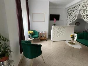 a living room with two green chairs and a table at Casa Eden Jupiter in Jupiter