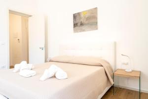 ein weißes Schlafzimmer mit einem Bett mit Handtüchern darauf in der Unterkunft Casa Del Barone - Luxury Suites in Monopoli