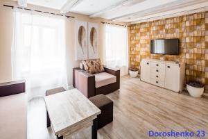 a living room with a tv and a couch and a table at Do Lvova Central Apartments in Lviv
