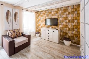 a living room with a couch and a tv at Do Lvova Central Apartments in Lviv