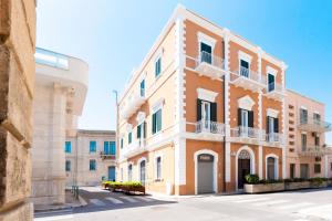 a large orange building with white trim on a street at Casa Del Barone - Luxury Suites in Monopoli