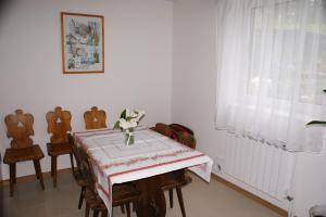 ein Esszimmer mit einem Tisch, Stühlen und einem Fenster in der Unterkunft Wypoczynek na Kurpiach in Kadzidło