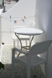 Korali Hotel في أنتيباروس تاون: طاولة بيضاء وكراسي وطاولة وكرسي