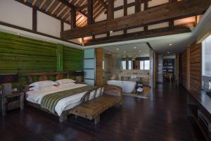 Slow Living Villa في نينغلانغ: غرفة نوم مع سرير وحوض استحمام في غرفة