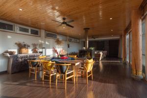 comedor con mesa y sillas amarillas en Slow Living Villa, en Ninglang