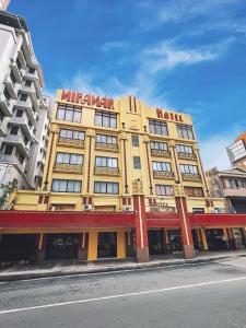 a yellow building with a sign on top of it at Miramar Hotel in Manila