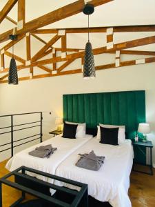 two beds in a room with a green headboard at Kates Nest Guesthouse Oshakati in Oshakati