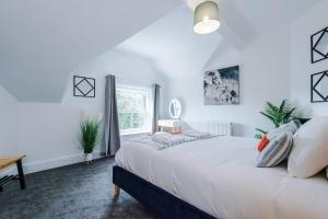 a white bedroom with a bed and a window at 2-Bed Victorian Oasis in Chester in Chester