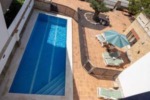 an overhead view of a swimming pool with chairs and an umbrella at Can Mirabell in Calders