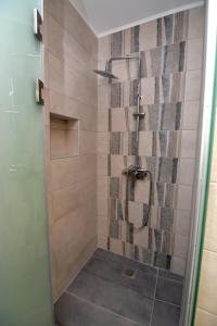 a bathroom with a shower with a glass door at Blue Lagoon 3 in Kavala +3 photos