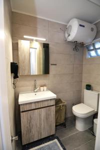 a bathroom with a sink and a toilet and a mirror at Blue Lagoon 3 in Kavala