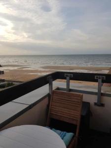 una silla sentada en un balcón con vistas a la playa en Appartement Liza 2 pièces Vue Mer à Cabourg, en Cabourg
