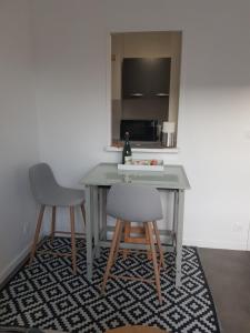 uma mesa e duas cadeiras num quarto em Appartement Liza 2 pièces Vue Mer à Cabourg em Cabourg
