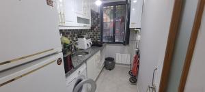 uma pequena cozinha com armários brancos e um lavatório em Sam home em Beylikdüzü