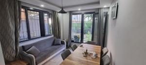 uma sala de estar com um sofá, uma mesa e janelas em Sam home em Beylikdüzü