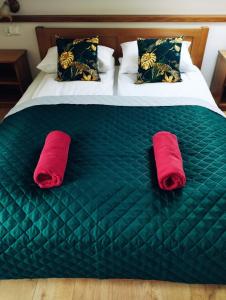 Zwei rote Handtücher liegen auf einem grünen Bett. in der Unterkunft Cisza i Spokój in Szczawnica