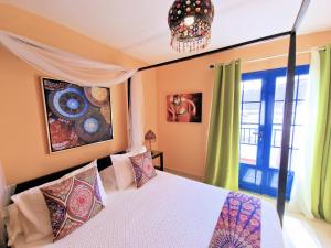 una camera con letto e lampadario a braccio di Suite Marrakech Beach, La Graciosa. a Caleta de Sebo