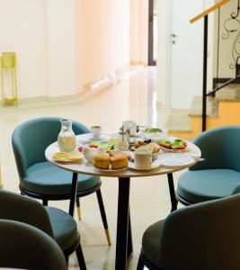 - une table avec de la nourriture et des chaises bleues dans l'établissement Hotel DownTown Avlabari, à Tbilissi