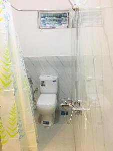 een witte badkamer met een toilet en een douche bij Kavee Transit Hotel in Katunayaka