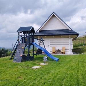 a playground with a slide in front of a house at Cisza i Spokój in Szczawnica