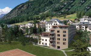 a building on a tennis court in front of a mountain at Sunstar Pontresina in Pontresina