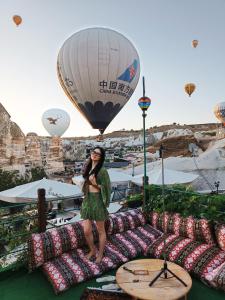 een vrouw op een bank met een heteluchtballon bij Vintage Cave House Hotel in Goreme