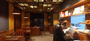 a man standing at a counter in a restaurant at Hotel Deysal Noora in Bomdila