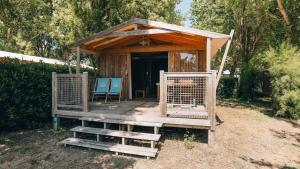 un abri en bois avec deux chaises bleues et une table dans l'établissement Camping La Prée, aux Portes