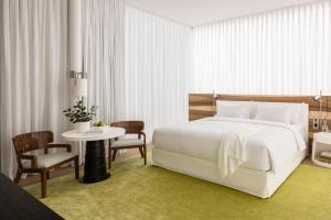 a bedroom with a white bed and a table and chairs at R48 Hotel and Garden in Tel Aviv