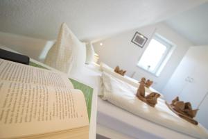 ein Schlafzimmer mit einem Buch und einem Bett mit ausgestopften Tieren in der Unterkunft Die Drei in Norddeich
