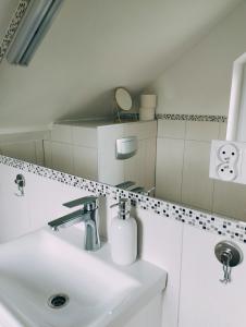 a white bathroom with a sink and a mirror at Cisza i Spokój in Szczawnica