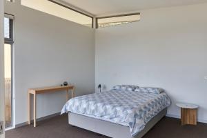 een slaapkamer met een bed in een witte kamer bij Ocean's 13 in Lorne