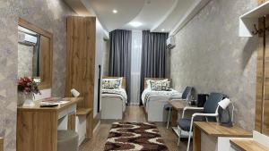 um quarto de hospital com duas camas e uma secretária em “Simbad” guest house em Jalal-Abad