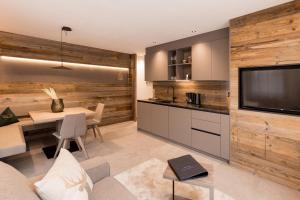 a kitchen and living room with a table and a tv at Obergasserhof Apt Waldruhe in Riscone