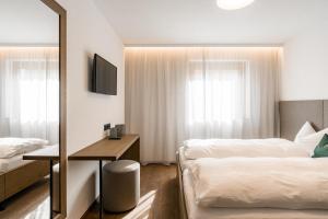 a hotel room with two beds and a mirror at Obergasserhof Apt Waldruhe in Riscone +15 photos