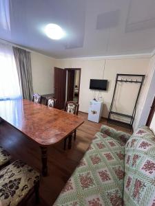 a living room with a wooden table and a couch at Гостиница Набережная in Balqash
